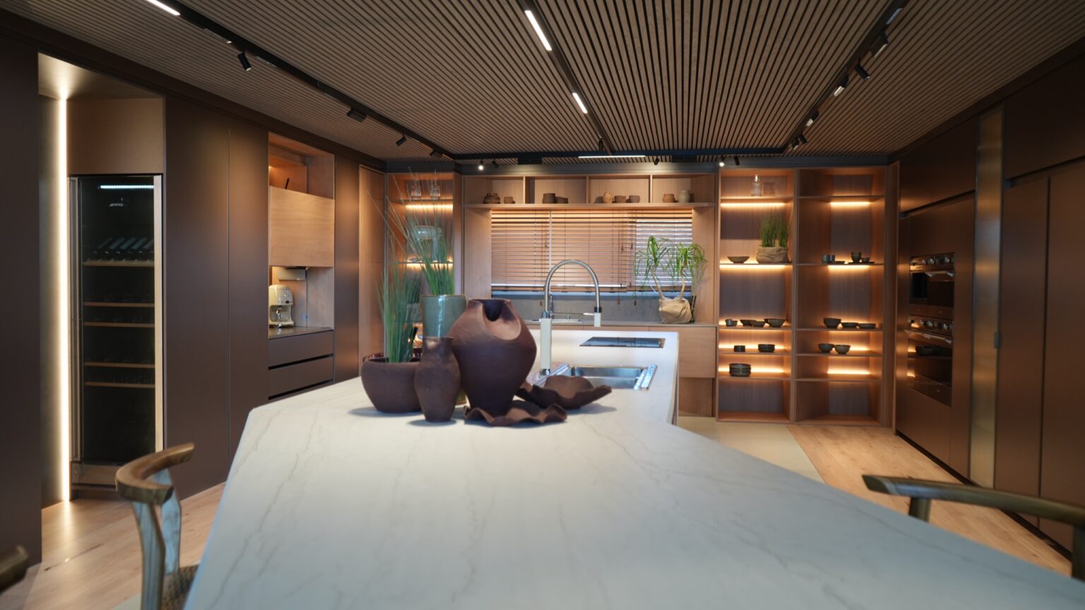 Cocina con isla de mármol y estantería iluminada