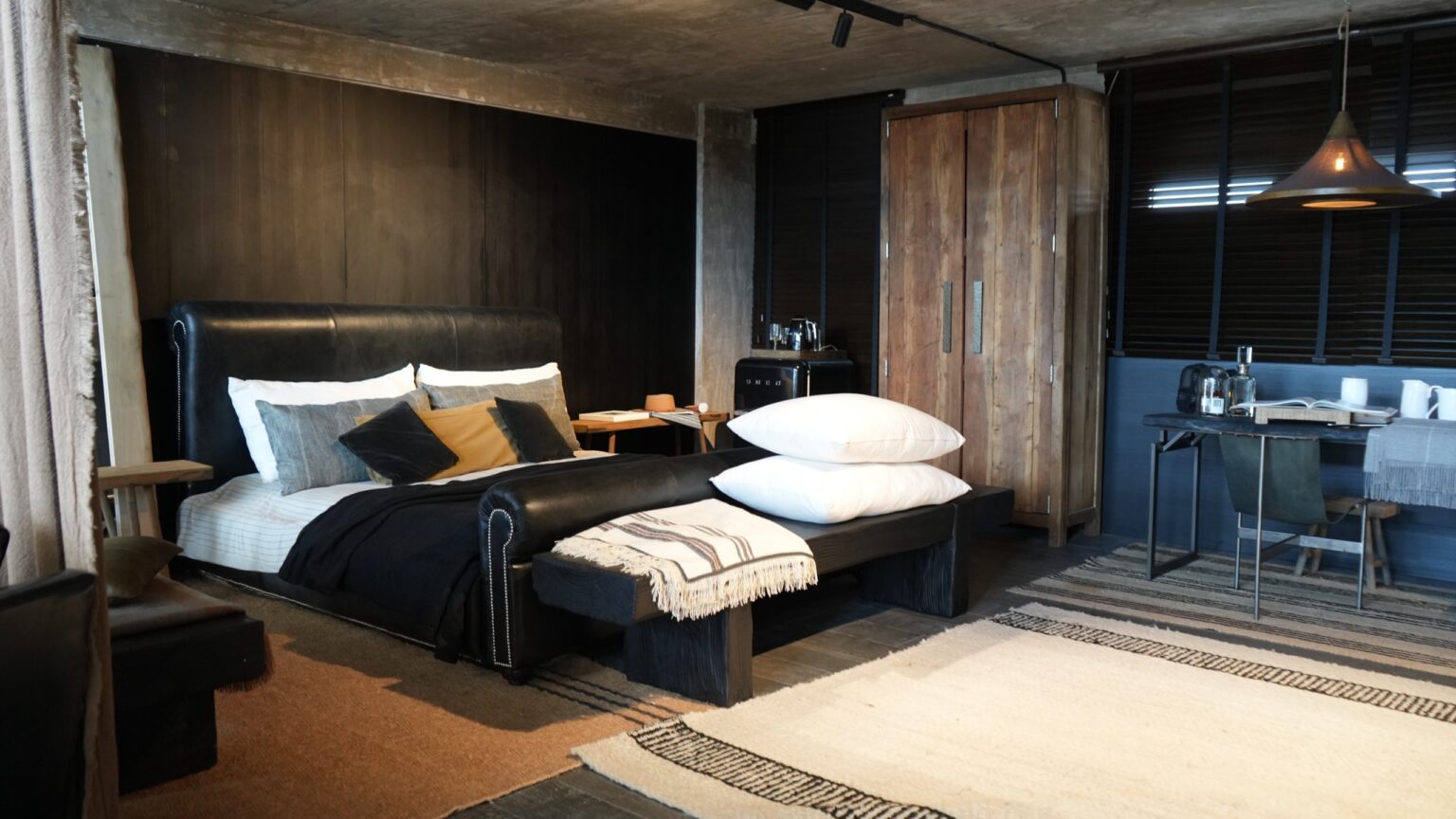 Dormitorio con cabecera de cuero y textiles naturales