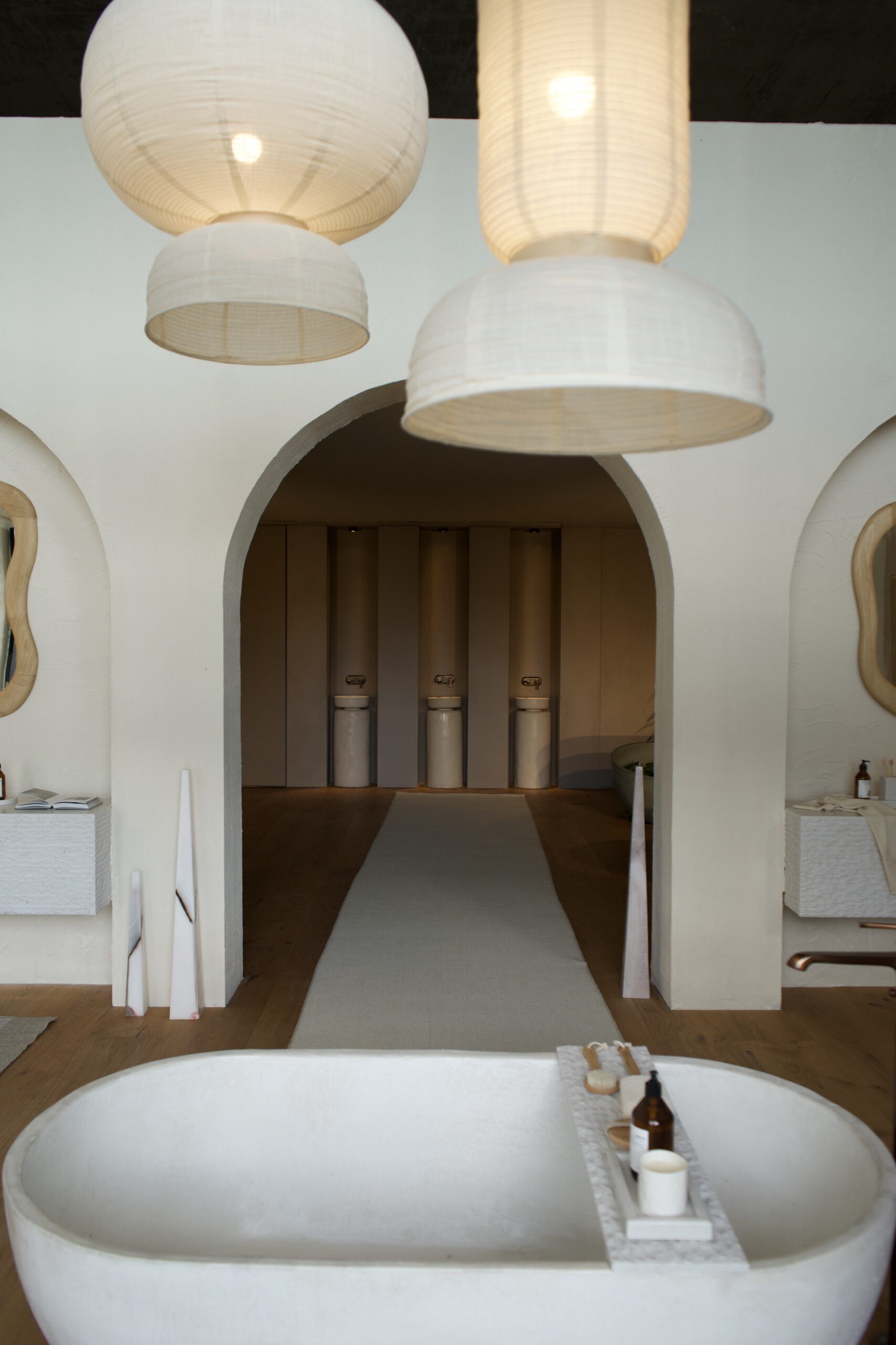 Baño con bañera exenta, arcos y lámparas de papel